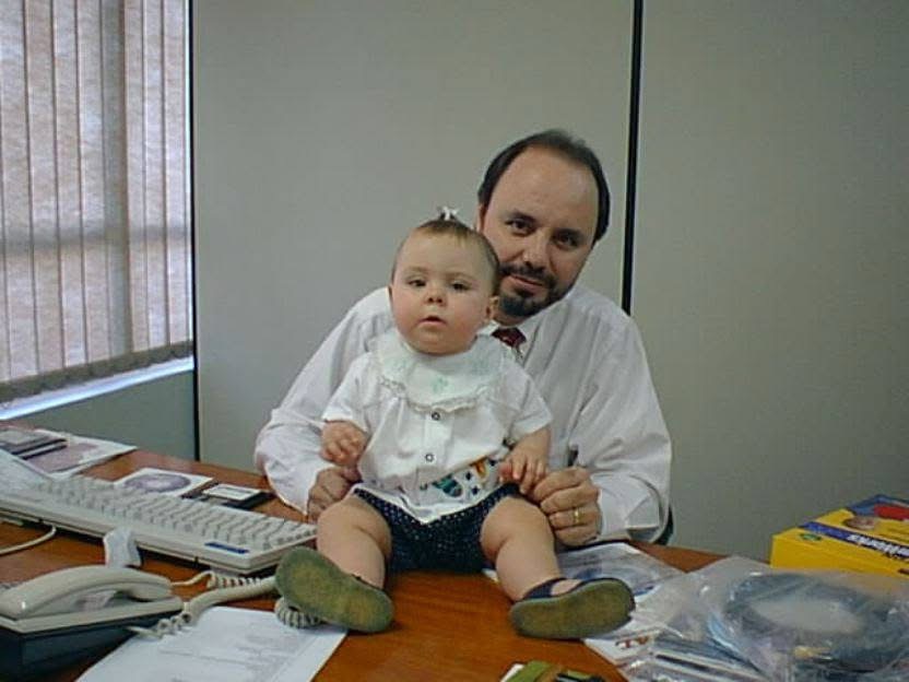 Marcos Welsh Carboni with baby Danielle at his computer desk — São Paulo
