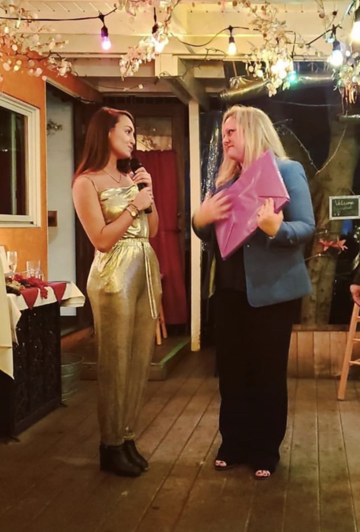 Danielle Vantini speaking at event — gold outfit